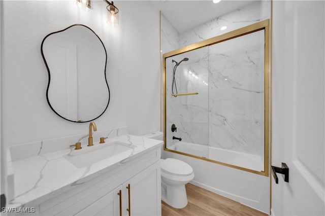 1517 Washington Ave, Lehigh Acres, FL 33972 - bathroom featuring vanity, combined bath / shower with glass door, and wood finished floors