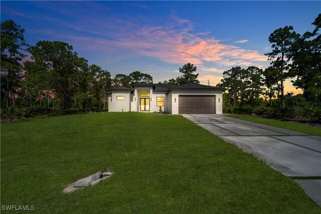 1517 Washington Ave, Lehigh Acres, FL 33972 - view of front of home featuring concrete driveway, a yard, a garage, and stucco siding