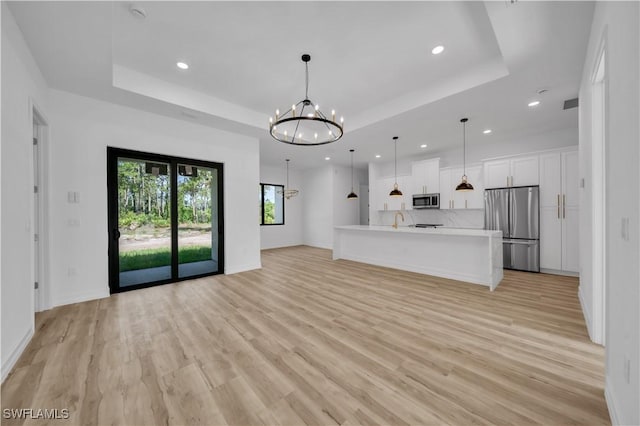 1517 Washington Ave, Lehigh Acres, FL 33972 - unfurnished living room with recessed lighting, a chandelier, a tray ceiling, and light wood-style floors