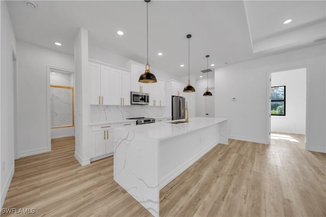 1517 Washington Ave, Lehigh Acres, FL 33972 - kitchen featuring stainless steel appliances, white cabinets, a spacious island, light wood finished floors, and recessed lighting