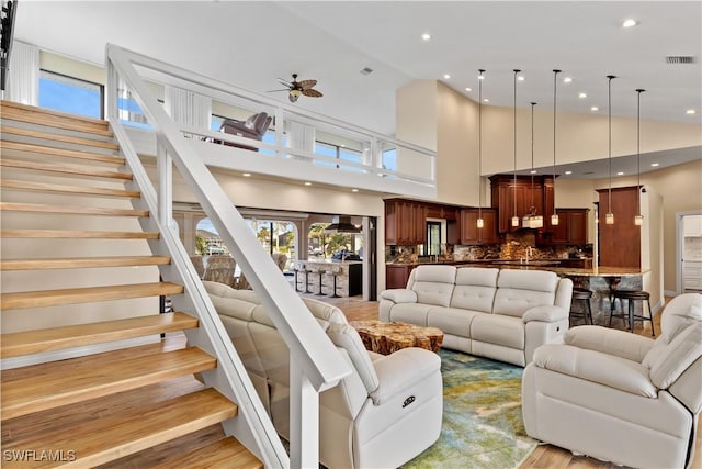 1701 Casey Key Dr, Punta Gorda, FL 33950 - living room featuring high vaulted ceiling, a ceiling fan, stairway, light wood-type flooring, and recessed lighting