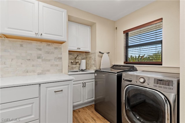1701 Casey Key Dr, Punta Gorda, FL 33950 - laundry area with washer and clothes dryer, cabinet space, and light wood-style floors