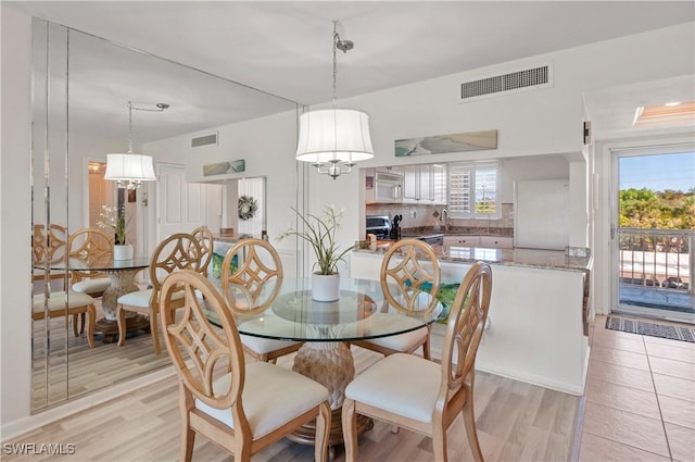 21 High Point Cir E Unit 308, Naples, FL 34103 - dining area featuring light wood-style flooring and a chandelier