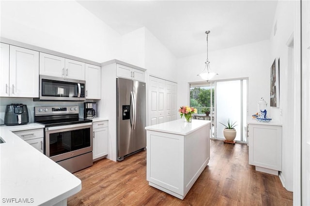 4945 Cougar Ct S Unit 4-202, Naples, FL 34109 - kitchen with appliances with stainless steel finishes, light countertops, a kitchen island, and light wood-type flooring