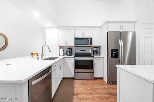4945 Cougar Ct S Unit 4-202, Naples, FL 34109 - kitchen featuring stainless steel appliances, a peninsula, light countertops, light wood-type flooring, and white cabinets