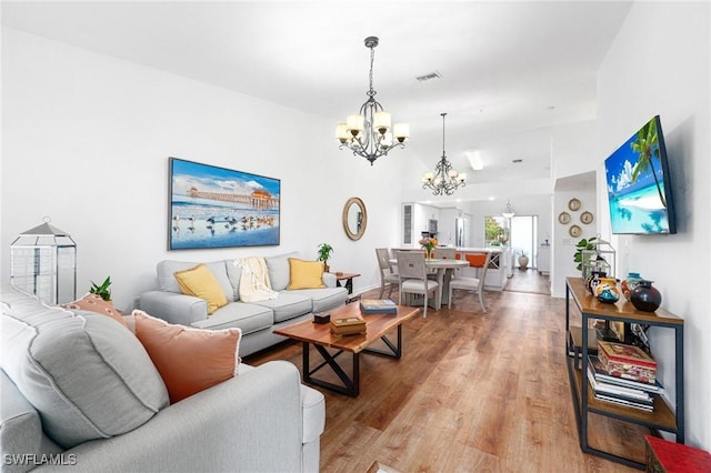4945 Cougar Ct S Unit 4-202, Naples, FL 34109 - living room featuring a chandelier and light wood-style flooring