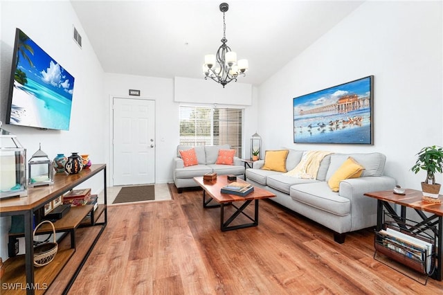 4945 Cougar Ct S Unit 4-202, Naples, FL 34109 - living area featuring a chandelier, wood finished floors, and lofted ceiling