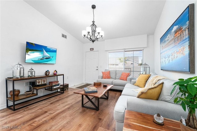 4945 Cougar Ct S Unit 4-202, Naples, FL 34109 - living room featuring a chandelier, wood finished floors, and lofted ceiling
