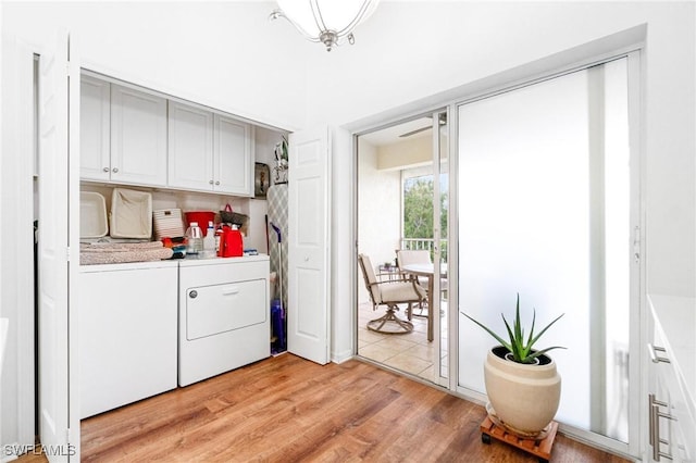 4945 Cougar Ct S Unit 4-202, Naples, FL 34109 - washroom featuring washing machine and clothes dryer, light wood-type flooring, and cabinet space