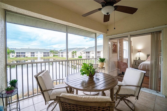 4945 Cougar Ct S Unit 4-202, Naples, FL 34109 - sunroom featuring tile patterned floors, a ceiling fan, vaulted ceiling, a water view, and a residential view