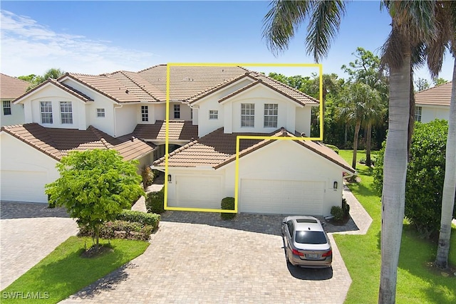 26962 Montego Pointe Ct Unit 202, Bonita Springs, FL 34134 - view of front of home with a garage, stucco siding, a tile roof, and decorative driveway