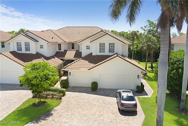 26962 Montego Pointe Ct Unit 202, Bonita Springs, FL 34134 - view of front of property with a tiled roof, stucco siding, driveway, and a front lawn