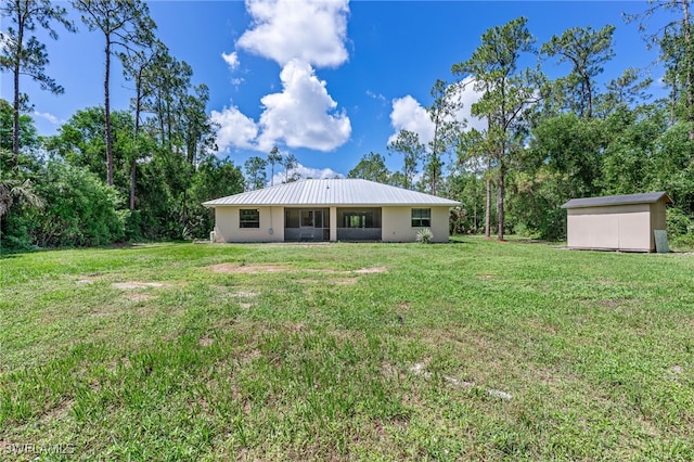 3191 Golden Gate Blvd E, Naples, FL 34120 - back of property with a shed, a yard, stucco siding, and a metal roof