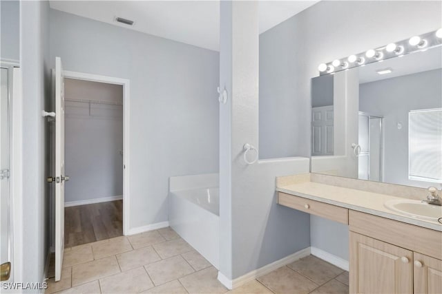1023 SE 6th St, Cape Coral, FL 33990 - bathroom featuring a garden tub, a spacious closet, vanity, a stall shower, and tile patterned floors