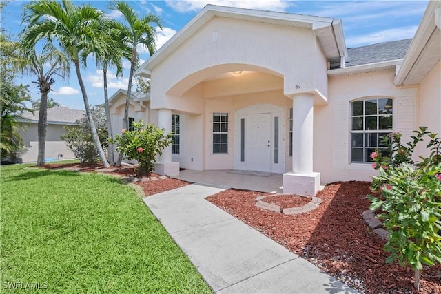 1023 SE 6th St, Cape Coral, FL 33990 - doorway to property with stucco siding and a lawn