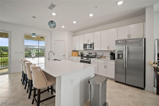 15887 Grassland Ln Unit 4622, Punta Gorda, FL 33982 - kitchen featuring appliances with stainless steel finishes, light tile patterned flooring, a center island with sink, white cabinets, and light countertops