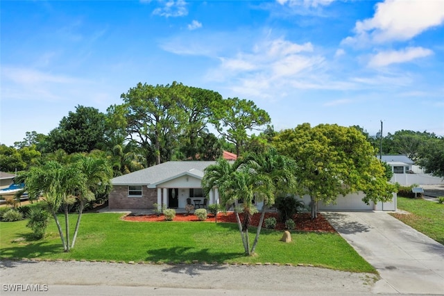 165 4th St, Bonita Springs, FL 34134 - view of front of property with driveway, a front yard, a garage, and covered porch