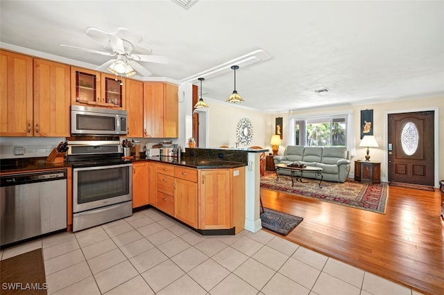 165 4th St, Bonita Springs, FL 34134 - kitchen featuring stainless steel appliances, a peninsula, open floor plan, pendant lighting, and glass insert cabinets