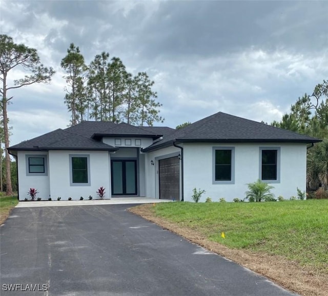 3534 Randall Blvd, Naples, FL 34120 - prairie-style home featuring stucco siding, a garage, asphalt driveway, a front yard, and a shingled roof