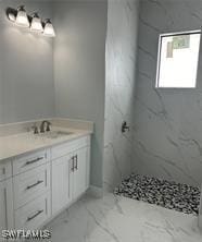 3481 24th Ave NE, Naples, FL 34120 - bathroom with vanity, tiled shower, and marble finish flooring