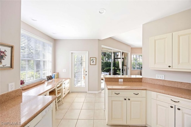 24400 Reserve Ct Unit 103, Bonita Springs, FL 34134 - kitchen with light tile patterned flooring, light countertops, and a peninsula