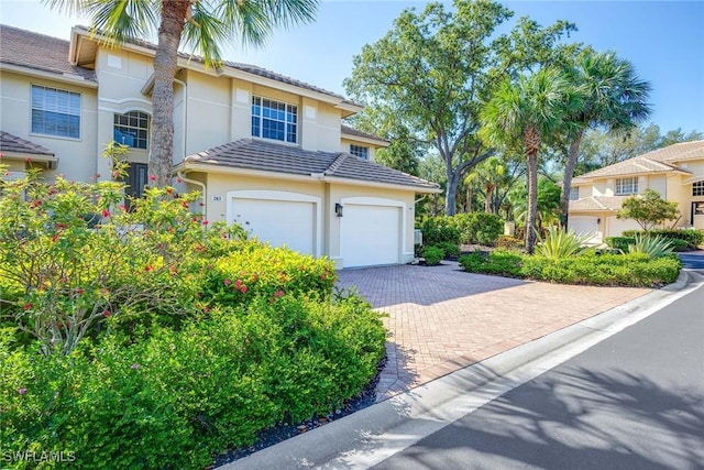 24400 Reserve Ct Unit 103, Bonita Springs, FL 34134 - view of front of house with a garage, driveway, and stucco siding