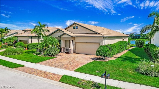14274 Arrow Point Ct, Estero, FL 33928 - view of front of property featuring a garage, decorative driveway, a front lawn, a tile roof, and stucco siding