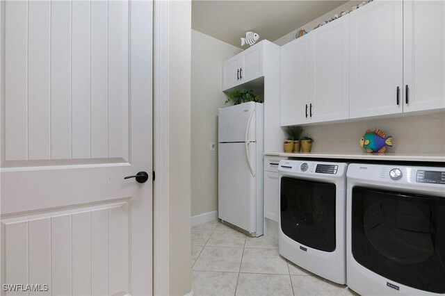 14274 Arrow Point Ct, Estero, FL 33928 - laundry room featuring separate washer and dryer, cabinet space, and light tile patterned floors