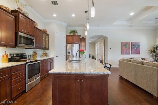 14274 Arrow Point Ct, Estero, FL 33928 - kitchen featuring appliances with stainless steel finishes, arched walkways, open floor plan, dark wood-type flooring, and light stone counters