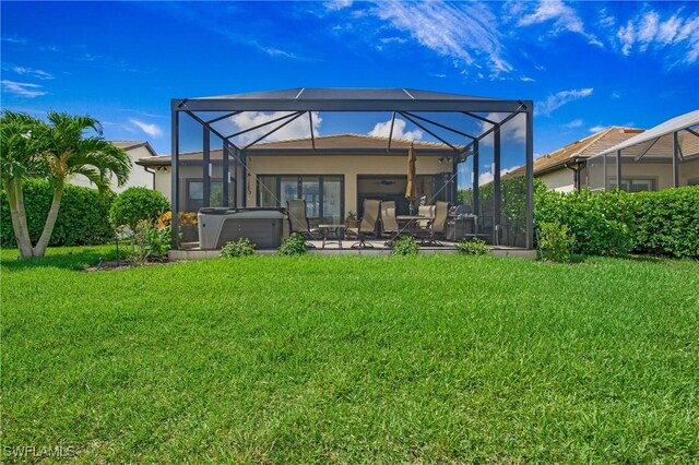 14274 Arrow Point Ct, Estero, FL 33928 - back of property with a hot tub, a patio area, a lawn, and glass enclosure