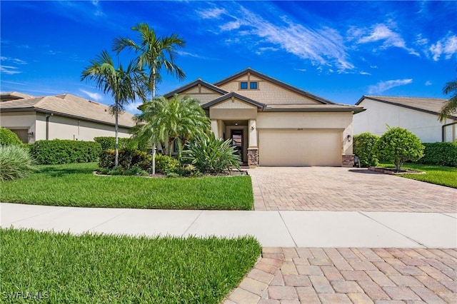 14274 Arrow Point Ct, Estero, FL 33928 - view of front of home with decorative driveway, an attached garage, stone siding, a front yard, and stucco siding