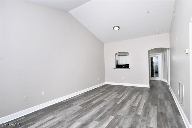 4154 Castilla Cir Unit 204, Fort Myers, FL 33916 - empty room with arched walkways, dark wood-type flooring, and vaulted ceiling