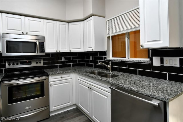 4154 Castilla Cir Unit 204, Fort Myers, FL 33916 - kitchen featuring appliances with stainless steel finishes, white cabinetry, decorative backsplash, and dark stone countertops