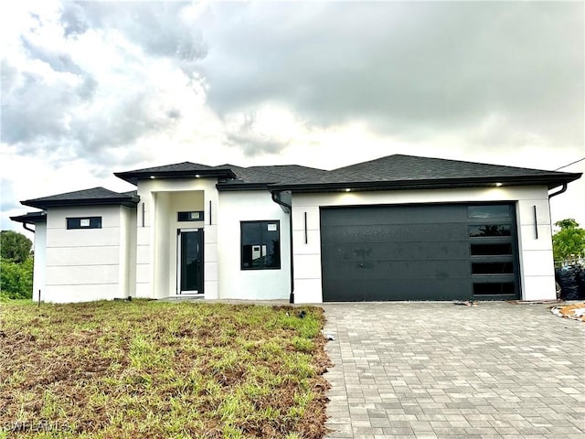 3201 2nd St SW, Lehigh Acres, FL 33976 - view of front of home with stucco siding, decorative driveway, and a garage