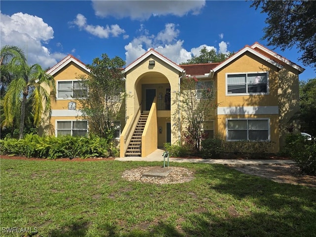 12551 Equestrian Cir Unit 704, Fort Myers, FL 33907 - view of front of property with stucco siding, a front lawn, and stairs