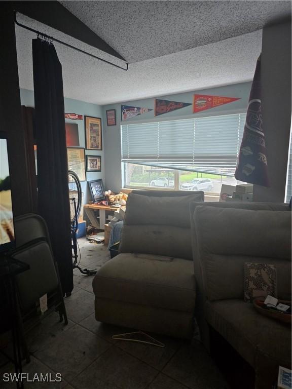 12551 Equestrian Cir Unit 704, Fort Myers, FL 33907 - tiled living room with a textured ceiling