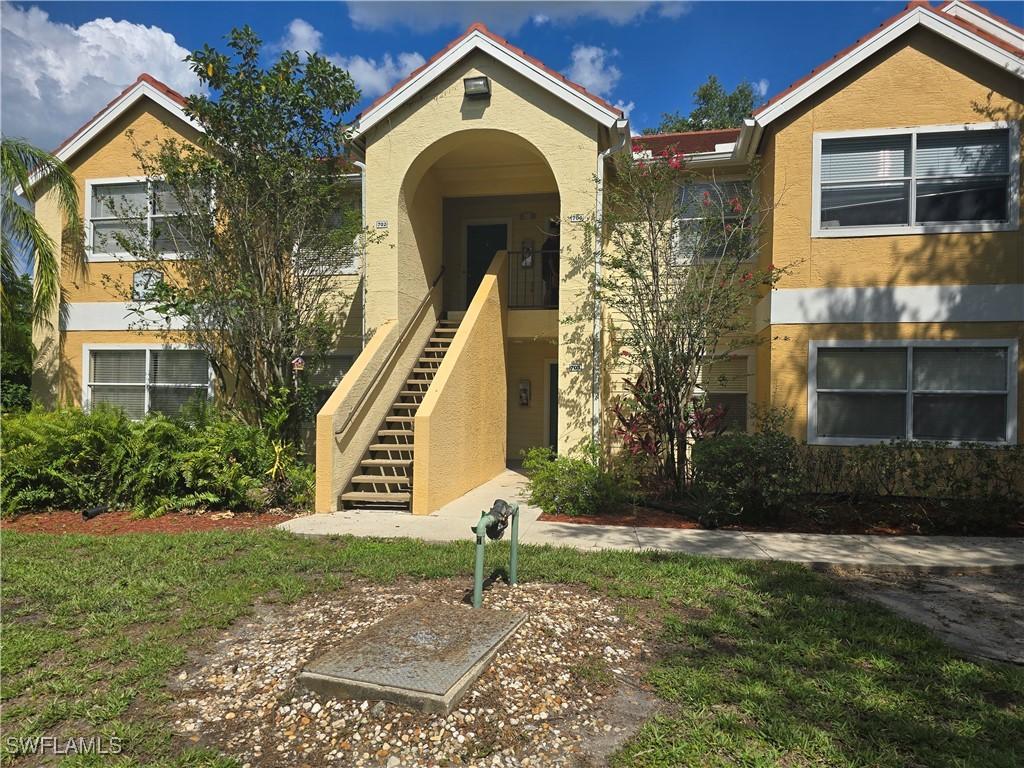 12551 Equestrian Cir Unit 704, Fort Myers, FL 33907 - view of front of house featuring stucco siding and stairway