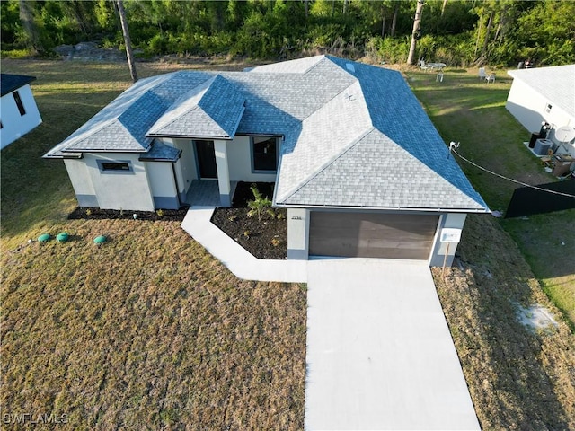 2714 2nd St SW, Lehigh Acres, FL 33976 - view of front of house with a garage, driveway, a front lawn, and a shingled roof