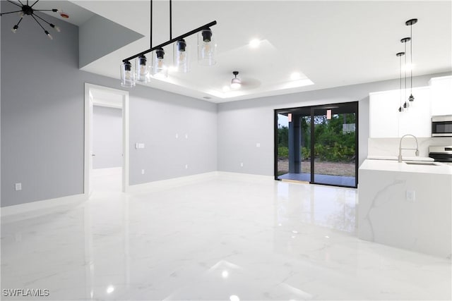 2714 2nd St SW, Lehigh Acres, FL 33976 - unfurnished living room featuring light marble finish flooring, a tray ceiling, and a chandelier