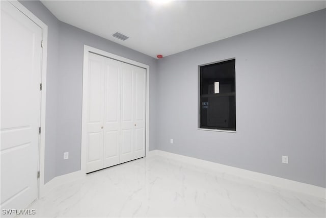 2714 2nd St SW, Lehigh Acres, FL 33976 - unfurnished bedroom featuring marble finish flooring and a closet