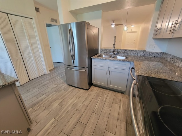 8313 Bernwood Cove Loop Unit 1211, Fort Myers, FL 33966 - kitchen with appliances with stainless steel finishes, light wood finished floors, ceiling fan, stone counters, and gray cabinetry