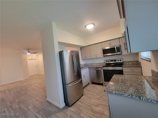8313 Bernwood Cove Loop Unit 1211, Fort Myers, FL 33966 - kitchen with stainless steel appliances, wood finish floors, dark stone counters, ceiling fan, and gray cabinets