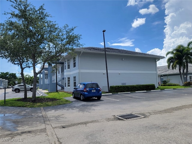 8313 Bernwood Cove Loop Unit 1211, Fort Myers, FL 33966 - view of side of property with uncovered parking and stucco siding