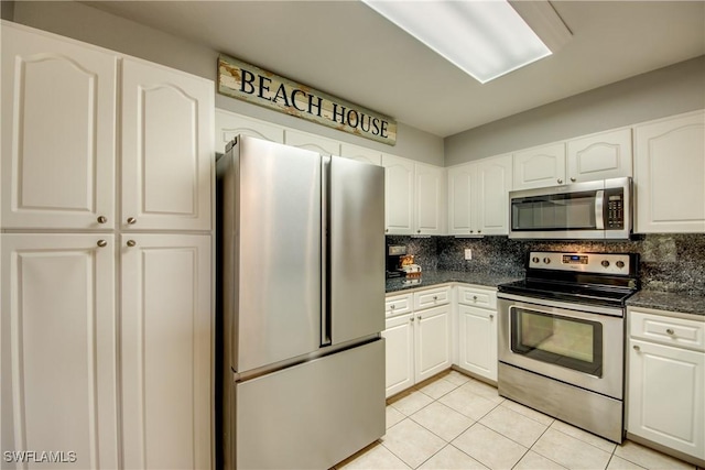 841 SW 47th Ter Unit 206, Cape Coral, FL 33914 - kitchen with appliances with stainless steel finishes, light tile patterned floors, tasteful backsplash, and white cabinetry