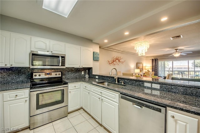 841 SW 47th Ter Unit 206, Cape Coral, FL 33914 - kitchen with stainless steel appliances, light tile patterned flooring, white cabinetry, backsplash, and recessed lighting
