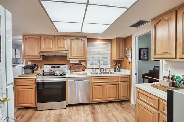 5554 Hamlet Ln, Fort Myers, FL 33919 - kitchen with stainless steel appliances, light countertops, under cabinet range hood, and light wood-style flooring