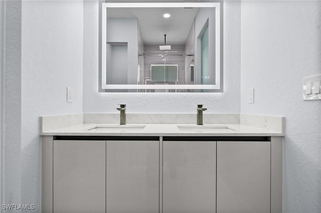 3990 27th Ave NE, Naples, FL 34120 - full bath with a textured wall, double vanity, and a shower