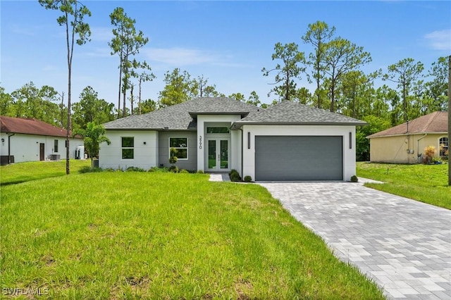 3990 27th Ave NE, Naples, FL 34120 - prairie-style house with french doors, a garage, a front lawn, and decorative driveway