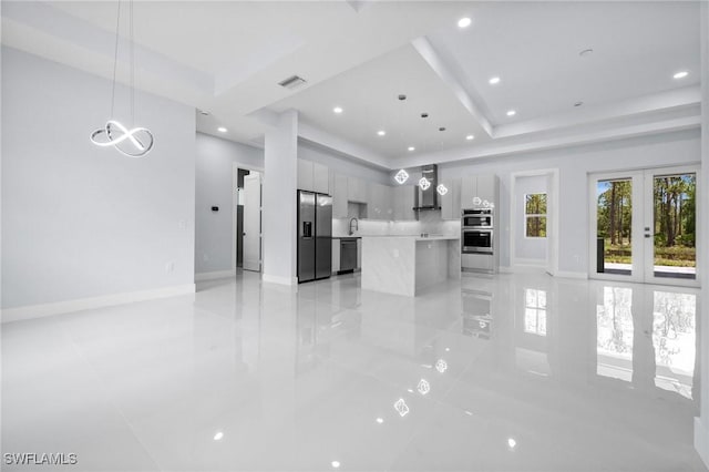 3990 27th Ave NE, Naples, FL 34120 - unfurnished living room featuring a tray ceiling, light tile patterned floors, french doors, recessed lighting, and a chandelier