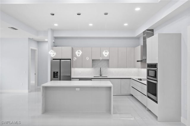 3990 27th Ave NE, Naples, FL 34120 - kitchen with stainless steel appliances, modern cabinets, light countertops, a kitchen island, and tasteful backsplash